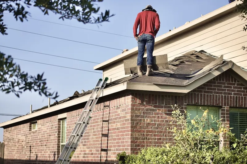 Professional roofer working on a residential roof in Holly House